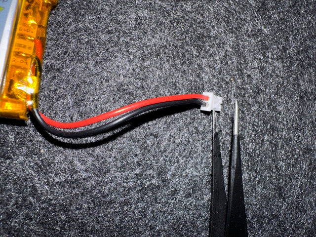 Battery plug with the wrong polarity A LiPo battery’s JST plug next to a pair of tweezers, with the red and black wires in the opposite positions to those on the battery clip