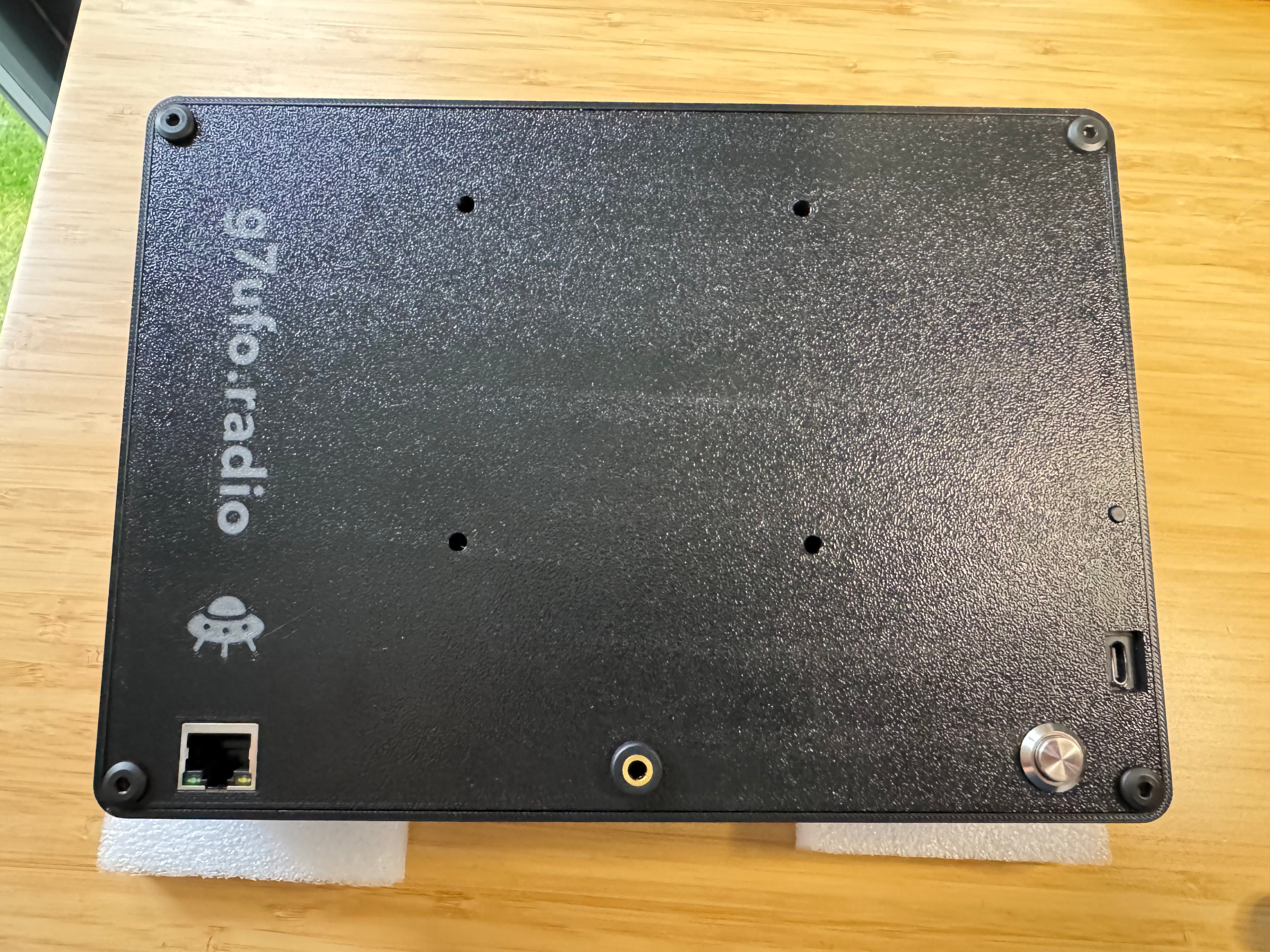 The closed case from the back, showing the g7ufo.radio logo, the Ethernet port, a 3.5mm socket and the power button